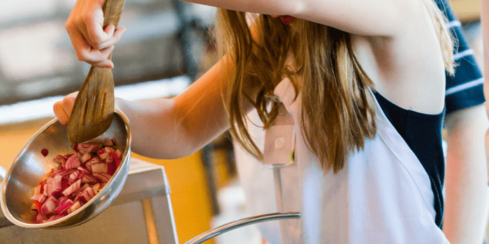 Child weighing ingredients indoors